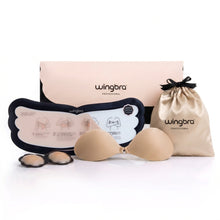 Wingbra professional silicone adhesive nude bra set with beige silicone cups, a black-and-white instruction card, a beige drawstring pouch, and a pink product box on a white background